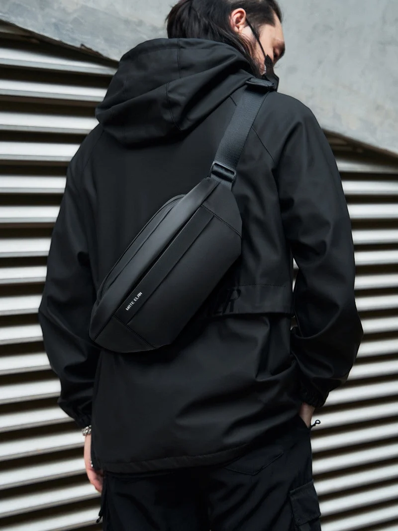 Crossbody väska i vattentåligt material, flera fack